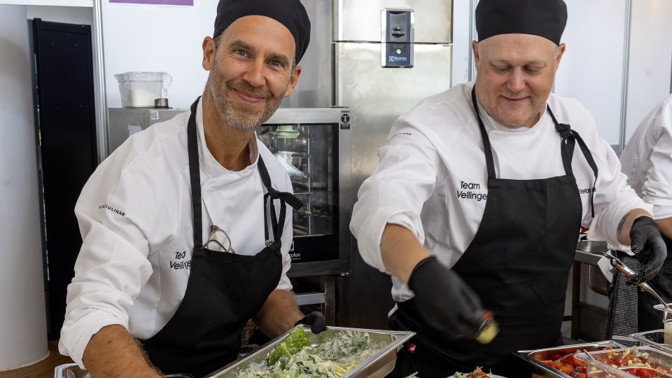 Två kockar lägger upp och serverar måltider